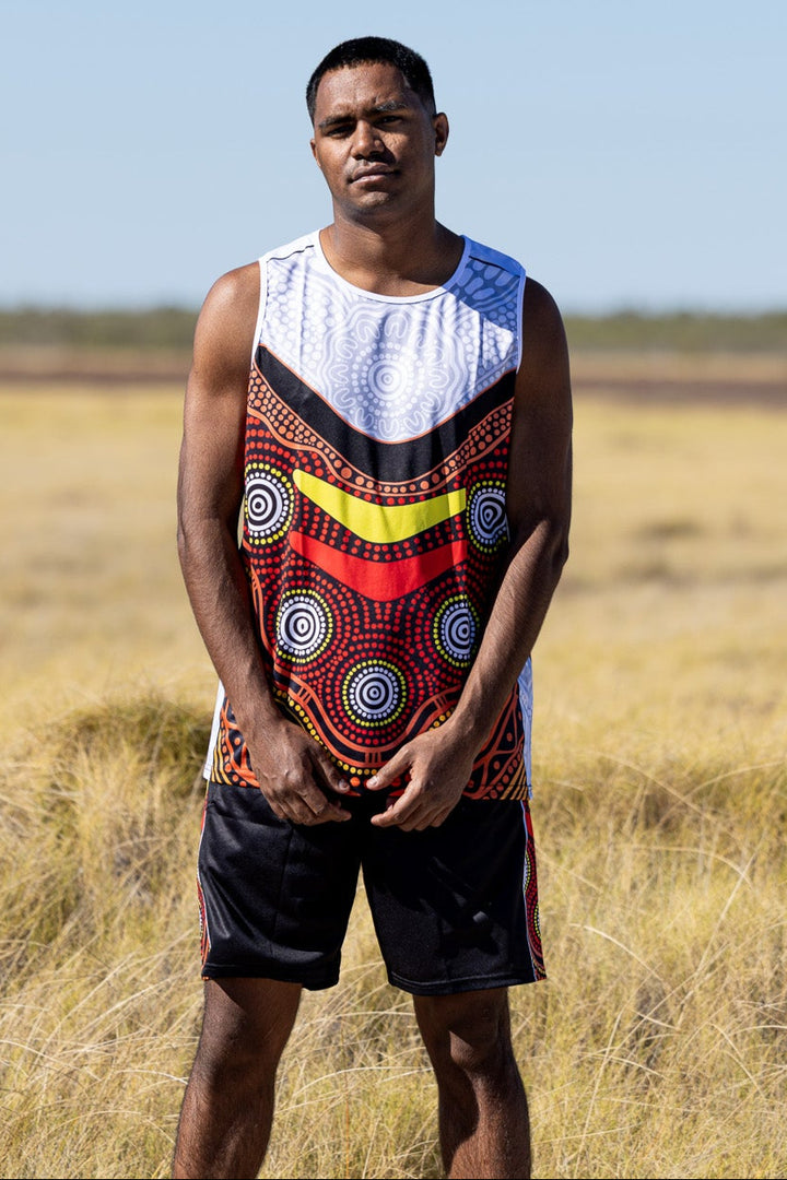 Person wearing a colorful sleeveless shirt with a pattern in a desert landscape